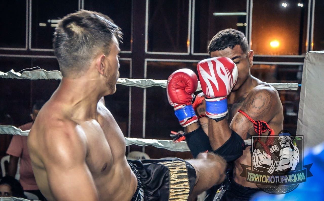 Kelinho Ávila in a Muay Thai fight, defending against strikes